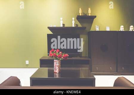 Petit salon avec un canapé marron, cabinet et plat Banque D'Images