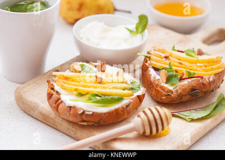 Des sandwichs avec du fromage cottage, de miel, de poire et de noix. Le petit-déjeuner est une collation saine. Banque D'Images