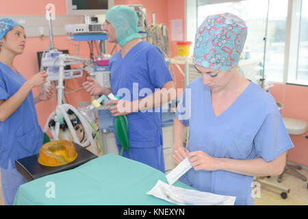 Équipe de chirurgiens dans la salle d'opération sombre Banque D'Images