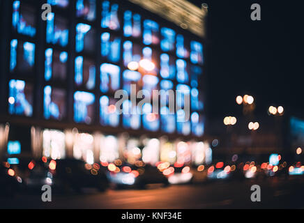 Ville la nuit brouillée. Bokeh. Beau résumé fond flou artistique avec les immeubles, les voitures, les lumières de la ville, les gens. Flou d'arrière-plan avec les couleurs Banque D'Images