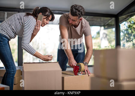 Couple packing up boîtes d'effets personnels dans les boîtes de carton Banque D'Images