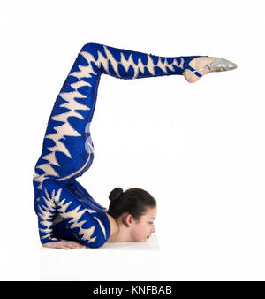Acrobat n'gymnastique, droit isolé sur un fond blanc. Un jeune artiste de cirque dans un costume bleu , remplir d'éléments acrobatiques. Banque D'Images