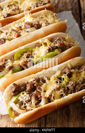 Des Philly Cheesesteak Sandwich avec oignons et poivrons macro sur le papier sur la table verticale. Banque D'Images