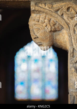 Détail de la SCULPTURE SUR PIERRE AUTOUR DE LA PORTE D'ENTRÉE, AVEC LES PRIEURS VITRAIL EN ARRIÈRE-PLAN, la cathédrale d'ELY, Ely, Cambridgeshire Banque D'Images