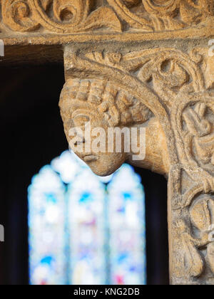 Détail de la SCULPTURE SUR PIERRE AUTOUR DE LA PORTE D'ENTRÉE, AVEC LES PRIEURS VITRAIL EN ARRIÈRE-PLAN, la cathédrale d'ELY, Ely, Cambridgeshire Banque D'Images