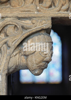 Détail de la SCULPTURE SUR PIERRE AUTOUR DE LA PORTE D'ENTRÉE, AVEC LES PRIEURS VITRAIL EN ARRIÈRE-PLAN, la cathédrale d'ELY, Ely, Cambridgeshire Banque D'Images