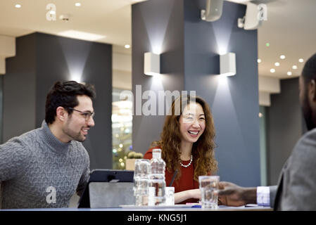 Asian businesswoman with caucasian et noir collègues masculins dans une réunion d'équipe dans un bureau contemporain Banque D'Images