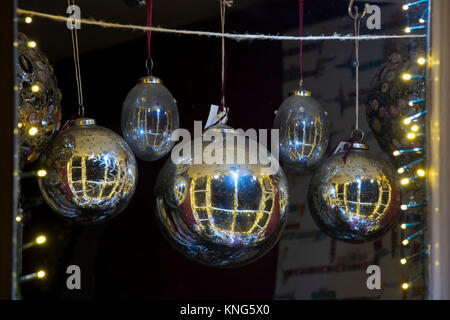 Boules de Noël suspendu dans une vitrine la nuit à Chipping Campden, Cotswolds, Gloucestershire, Angleterre Banque D'Images