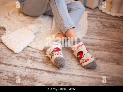 Fille assise sur le plancher Winter socks Banque D'Images