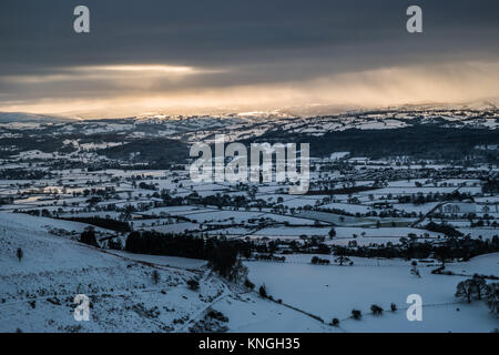 Neige scène sur la vallée de Clwyd avec le soleil sur le point d'établir. Prises de Moel Famau, décembre 2017. Banque D'Images