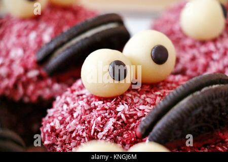 Muffin rouge ressemble à un drôle de monstre avec de grandes lèvres et de grands yeux Banque D'Images