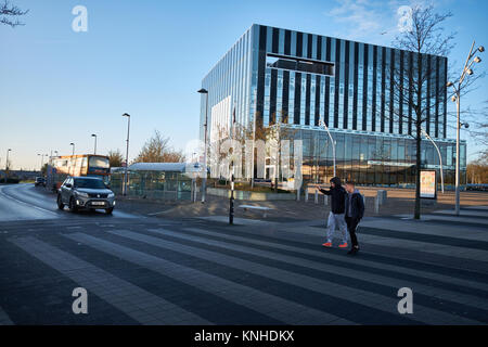 Deux jeunes hommes sur le passage pour piétons entre la municipalité et la Société de construction de Cube street Shopping Centre à Corby, Northants, England. Banque D'Images