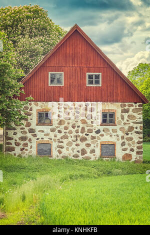 Une ancienne grange en pierre avec toiture en bois situé dans la campagne de Le Skane région. Banque D'Images