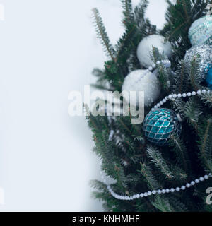 Un arbre de Noël décoré avec des ornements minimalistes en blanc, argent et bleu. Perles blanches sur les branches de sapins. Branches couvertes avec Banque D'Images