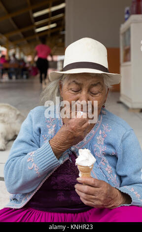 Équateur - une vieille femme équatorienne indigène woman eating ice cream, Cuenca, Équateur Amérique du Sud Banque D'Images