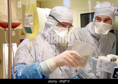 L'assistant technique pharmaceutique et biologique la Nemetz Michael Technicien de laboratoire Simon Kuebler (R) travaillent sur une nouvelle forme de thérapie cellulaire personnalisée contre le cancer avec la technologie hautement spécialisés à l'intérieur d'une chambre propre à l'Institut Fraunhofer pour la thérapie cellulaire et l'immunologie (IZI) à Leipzig, Allemagne, 20 novembre 2017. L'institut Fraunhofer travaille sur le projet conjoint avec le Novartis Pharma AG, afin de pouvoir élaborer la nouvelle forme de thérapie, la thérapie récepteur antigénique chimérique (panier). Il exige la reprogrammation de l'patients· propres cellules immunitaires pour traiter leur Banque D'Images