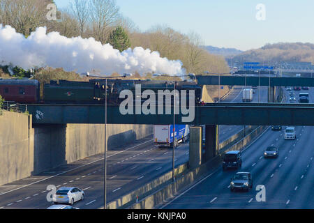 Merstham, UK. Dec 12, 2017. 'La Belle Sussex Noël' BR British Rail Britannia Classe 7MT 4-6-0 N° 70013 'Oliver Cromwell' la vitesse de la Locomotive à vapeur à travers les huit lane autoroute M25 à Merstham à Surrey, en route à Eastbourne, 1151h Le mardi 12 décembre 2017. Crédit photo : Lindsay : Le gendarme/Alamy Live News Banque D'Images