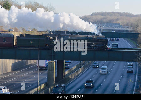 Merstham, UK. Dec 12, 2017. 'La Belle Sussex Noël' BR British Rail Britannia Classe 7MT 4-6-0 N° 70013 'Oliver Cromwell' la vitesse de la Locomotive à vapeur à travers les huit lane autoroute M25 à Merstham à Surrey, en route à Eastbourne, 1151h Le mardi 12 décembre 2017. Crédit photo : Lindsay : Le gendarme/Alamy Live News Banque D'Images