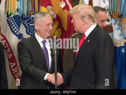 Le Président des Etats-Unis, Donald J. Trump, serre la main droite avec le secrétaire de la Défense Jim Mattis, gauche, avant de faire des observations et de la signature d'H.R. 2810, National Defense Authorization Act pour l'exercice 2018, dans la Roosevelt Room de la Maison Blanche à Washington, DC le Mardi, Décembre 12, 2017. Credit : Ron Sachs/CNP /MediaPunch Banque D'Images