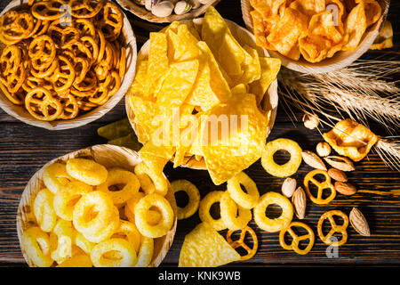 Vue de dessus des plaques avec des collations près de blé, les noix et les bretzels éparpillés sur le bureau en bois sombre. Aliments et boissons concept Banque D'Images