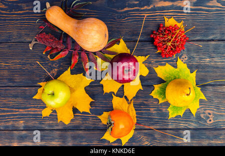 Vue de dessus de la récolte de pommes, poires, Rowan, potiron et persimmon allongé sur les feuilles. L'action de grâce et l'automne concept Banque D'Images