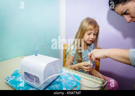 Femme prépare l'inhalation de traitement pour enfant avec des problèmes d'asthme. Banque D'Images