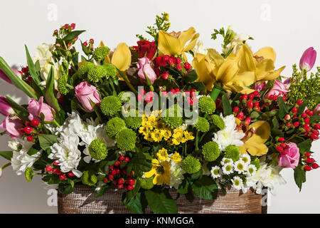 Composition de fleurs de roses rose, jaune orchidées, tulipes rouges, jacinthe et hrzemtem. Arrangement floral dans une boîte pour une fille de roses, tulipes et Banque D'Images