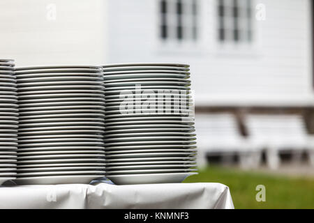 Gros tas de plaques de propreté et de fraîcheur à l'extérieur de séchage sur table avec nappe blanche Banque D'Images