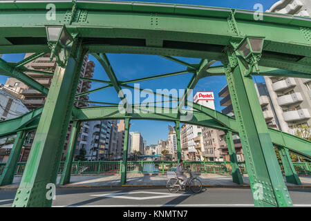 Homme monté sur un vélo à Yanagi Bridge (Yanagibashi) plus de Kanda (Kandagawa). Pont d'Asakusabashi (Asakusa) dans l'arrière-plan Banque D'Images