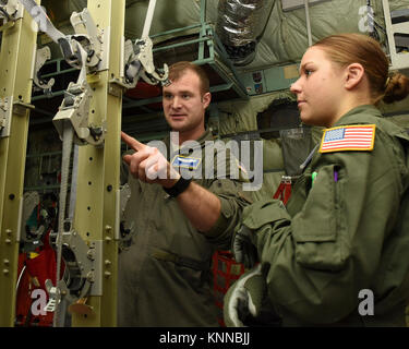 Le sergent de l'US Air Force. Branden Bières, un examinateur de vol avec le 375e groupe d'opérations, le détachement 4, situé à Wright-Patterson Air Force Base, Ohio, aide la haute Airman Courtney Loewen, à partir de la 86e Escadron d'évacuation aéromédicale, Base aérienne de Ramstein, en Allemagne, dans la configuration des supports de poteau sur le C-130 Hercules dans le cadre de l'unité de formation formelle au cours de fonctionnement 711e aile de la performance humaine de l'US Air Force de l'École de médecine aérospatiale, Wright-Patterson Air Force Base, Ohio, le 1 décembre, 2017. Chaque année USAFSAM fournit l'évacuation aéromédicale d'infirmières, de techniciens et de Soins Intensifs Banque D'Images