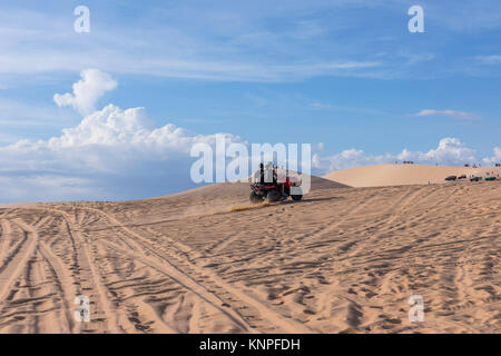 Dunes près de Mui Ne. Groupe de hors route au-dessus de dunes dans l'arrière-plan. Journée ensoleillée avec ciel bleu et nuages. Dunes de sable de Mui Ne au Vietnam , Banque D'Images