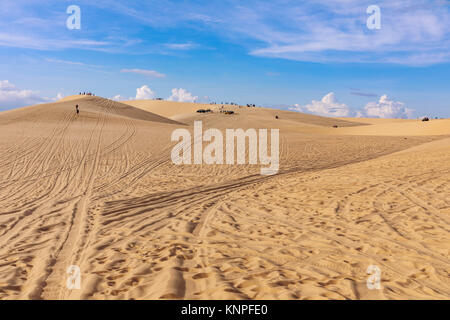 Dunes près de Mui Ne. Groupe de hors route au-dessus de dunes dans l'arrière-plan. Journée ensoleillée avec ciel bleu et nuages. Dunes de sable de Mui Ne au Vietnam , Banque D'Images