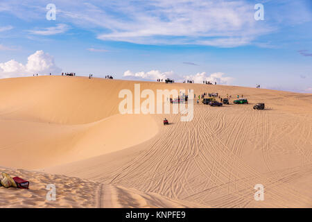 Dunes près de Mui Ne. Groupe de hors route au-dessus de dunes dans l'arrière-plan. Journée ensoleillée avec ciel bleu et nuages. Dunes de sable de Mui Ne au Vietnam , Banque D'Images