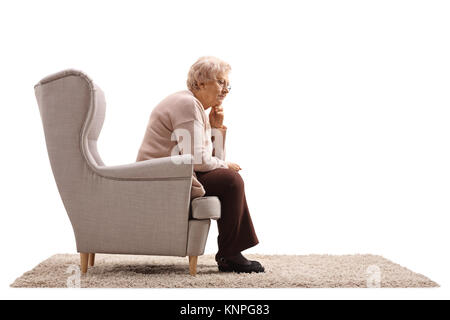 Les personnes âgées déprimées femme assise dans un fauteuil isolé sur fond blanc Banque D'Images