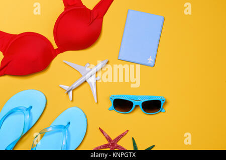 Vacances de Noël concept - avion, tongs, avion, Passeport,lunettes de soleil sur fond jaune Banque D'Images