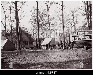 Photographie d'Andrew Joseph Russell représentant le quartier général Butler à Chapin's Farm, en Virginie, prise entre 1861 et 1865. L'image montre un groupe d'hommes debout devant une tente, avec un tenant une brouette, capturant un moment pendant la guerre de Sécession. Banque D'Images