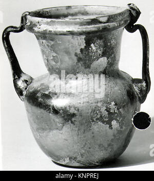Pot en verre romain avec deux poignées, 4ème–5ème siècle après J.-C., 4 1/2 pouces de haut, utilisé pour stocker des liquides, illustrant les anciennes techniques romaines de verrerie. Banque D'Images