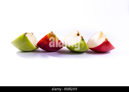 Les tranches de pomme rouge vert délicieux morceaux de fruits frais quarts blanc fond isolé Snack Banque D'Images