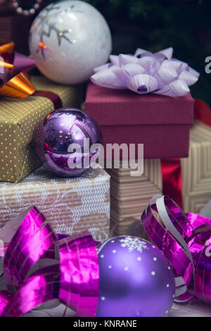 Boîtes cadeaux de taille différente avec des arcs métalliques, arbre de Noël, et en violet et lilas couleurs. Close up Banque D'Images