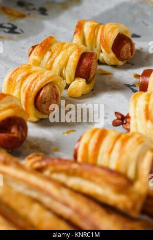 Rouleaux de pâte filo avec saucisse et bâtonnets de fromage salé sur la plaque de cuisson Banque D'Images