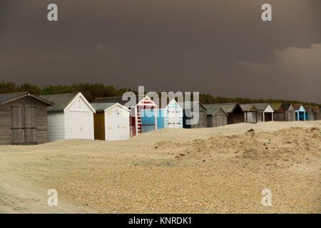 Cabines de plage à West Wittering Beach menacés en empiétant sand Banque D'Images
