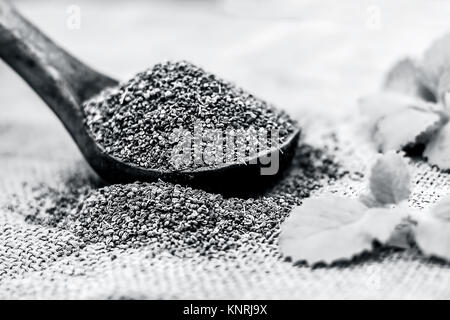 Trachyspermum ammi, graines d'Ajwain dans un scoop en bois avec quelques feuilles sur un fond de jute. Banque D'Images