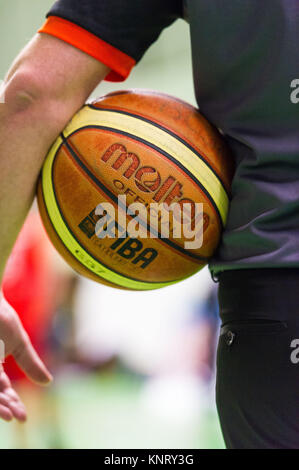 Basket-ball en fusion, la FIBA ballon officiel : arbitre tenant une boule sous son bras Banque D'Images