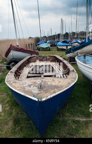 Boat Club dériveurs tous alignés dans un champ par le quai en attente pour les propriétaires de les sortir l'un l'eau sur un week-end ensoleillé. Banque D'Images