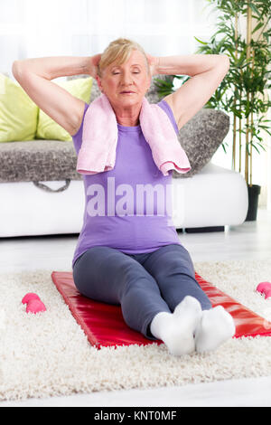 Senior woman doing stretching exercises,les yeux fermés Banque D'Images