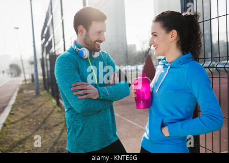 Sportif et de la sportive flirter piscine après exercice de remise en forme