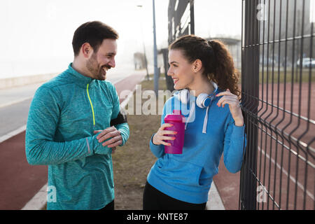 Sportif et de la sportive flirter piscine après exercice de remise en forme