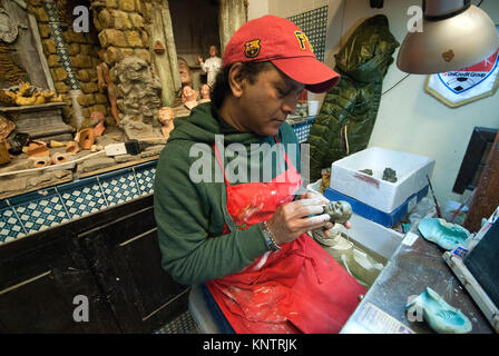Une statue en terre cuite artisan travaillant dans le célèbre atelier de Giuseppe et Marco Ferrigno, Via San Gregorio Armeno, Naples, Campanie, Italie Banque D'Images