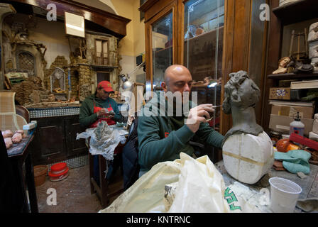 Les artisans qui travaillent une statue en terre cuite dans le célèbre atelier de Giuseppe et Marco Ferrigno, Via San Gregorio Armeno, Naples, Campanie, Italie Banque D'Images