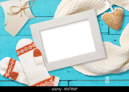 Cadre blanc de Noël maquette avec mitaines tricotés, flatlay sur un fond en bois blanc avec un ruban, avec place pour votre texte Banque D'Images